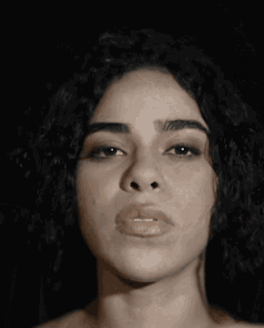a close up of a woman 's face with her hands on her face