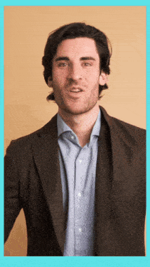 a man wearing a suit and a blue shirt is making a funny face
