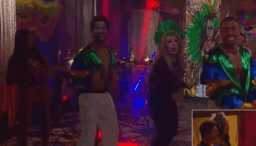 a group of people are dancing in a room with masks in the background