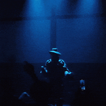 a man in a hat is standing in front of two lights