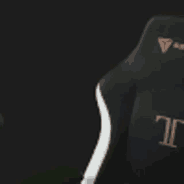 a close up of a black and white gaming chair in a dark room with a black background .