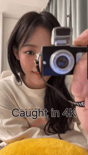 a girl taking a picture with a camera with the words caught in 4k below her
