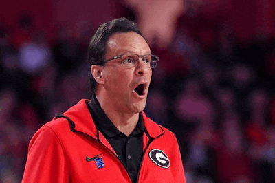 a man wearing a red jacket with the letter g on the front