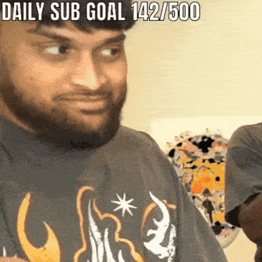 a man with a beard is wearing a shirt that says daily sub goal 142/500 on it