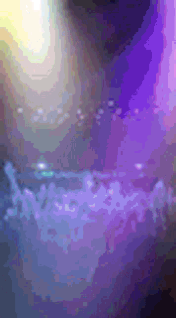 a blurry picture of a purple and blue background with a few bubbles in it .
