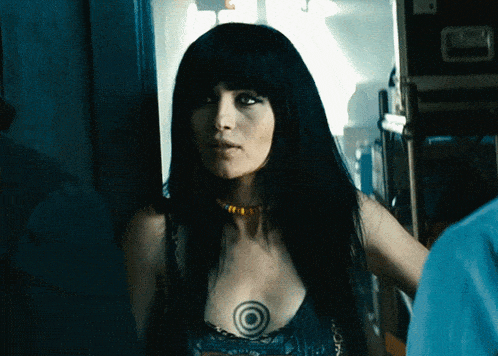 a woman with long black hair and a tattoo on her chest