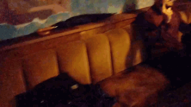 a blurry picture of a man sitting on a brown couch