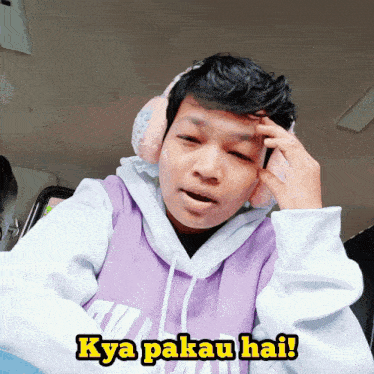a young man wearing ear muffs and a purple sweatshirt says kya pakau hai