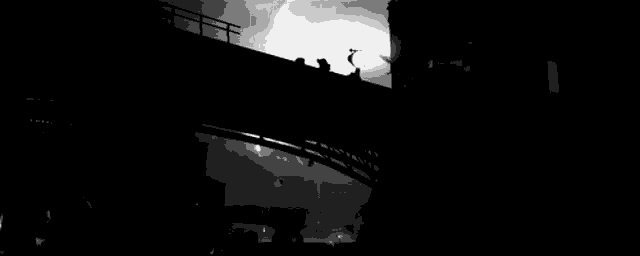 a black and white photo of a bridge with a lightning bolt coming down it .