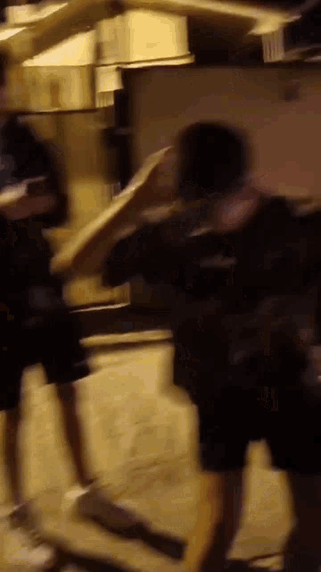 a blurry picture of two men standing next to each other in a dark room