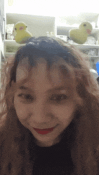 a woman with a headband on her head is smiling in front of two stuffed birds