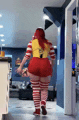 a woman in a mcdonald 's costume is walking in a hallway .