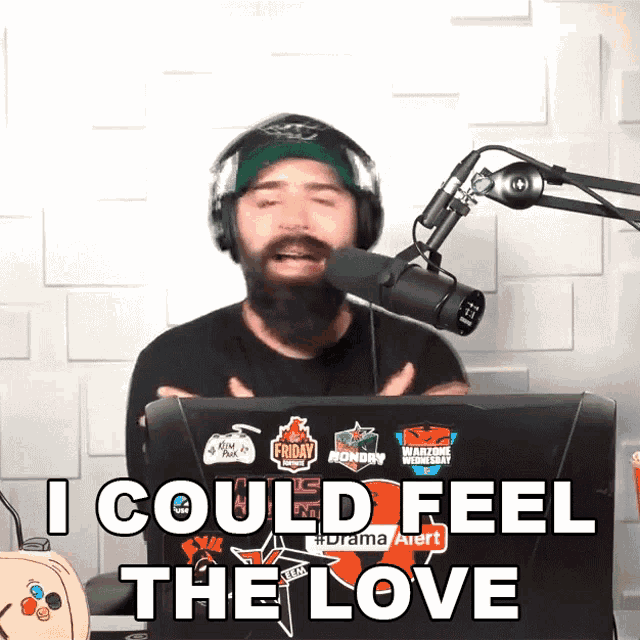 a man wearing headphones and a headband says " i could feel the love " in front of a microphone