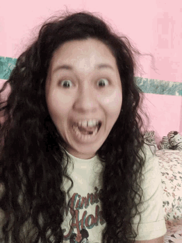 a woman with long curly hair wearing a shirt that says hawaii