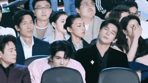 a group of people are sitting in a theatre watching a movie