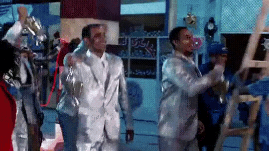 a group of men in suits are dancing in a room