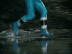 a person in a blue superhero costume is jumping over a puddle of water