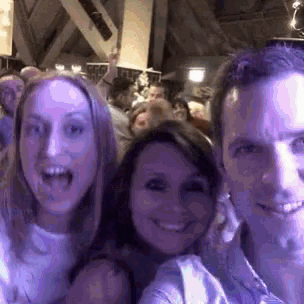 a man and two women are posing for a picture at a party