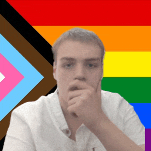 a man in front of a rainbow flag