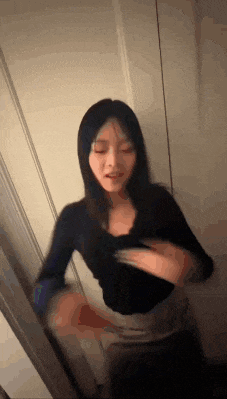 a woman is standing in front of a mirror and looking at herself .