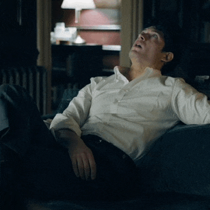 a man in a white shirt is sitting on a couch