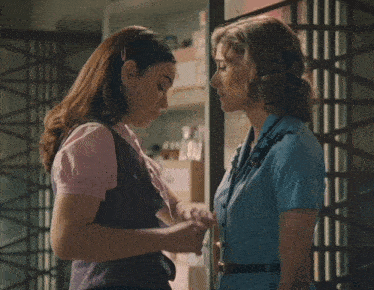 two women are standing next to each other talking