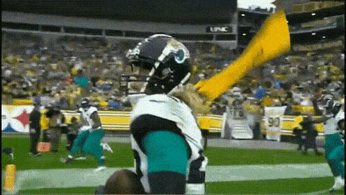 a football player in a jaguars uniform is holding a yellow flag