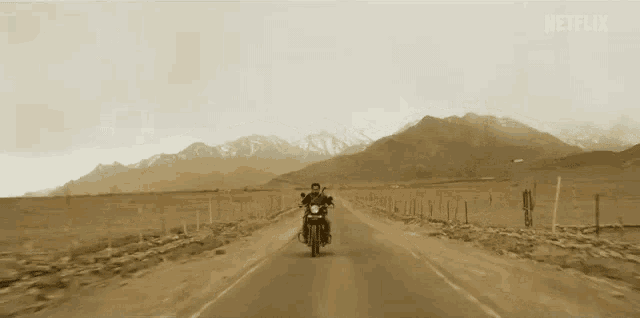 a man is riding a motorcycle down a deserted road .