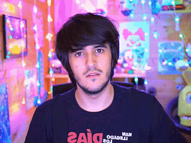 a man with a beard wears a black shirt that says 2aid