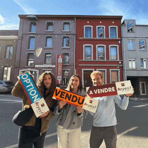 a group of people holding up signs one of which says vendu