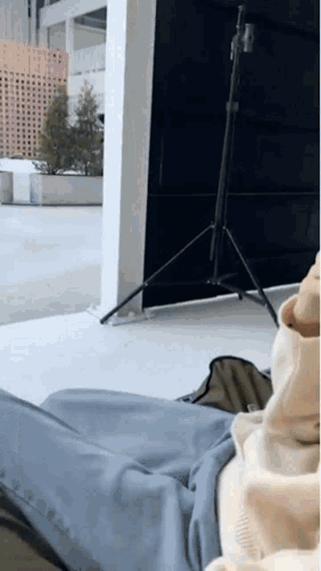 a person is laying on the ground with their legs crossed in front of a camera stand