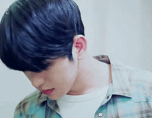 a close up of a man 's face with a plaid shirt on