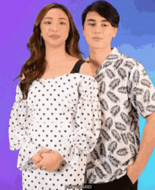 a woman in a polka dot dress and a man in a leaf print shirt