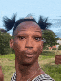 a man with pigtails on his head looks at the camera