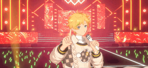 a boy is singing into a microphone on a stage while giving a thumbs up sign .