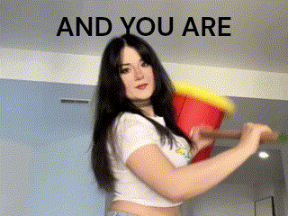 a woman in a white crop top is holding a red and yellow bucket in her hands .