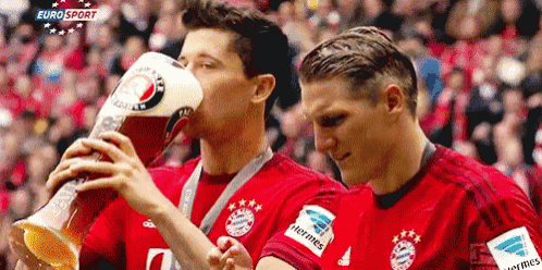 two soccer players drinking from a trophy with eurosport written in the background