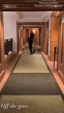 a woman is walking down a hallway with the words off she goes on the floor