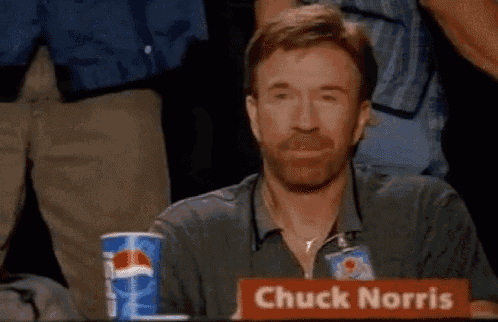 chuck norris is sitting at a table with a pepsi cup in front of him