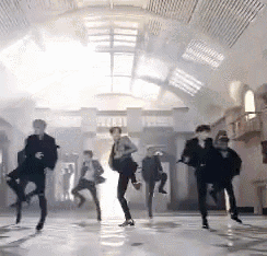a group of people are dancing in a hallway in a building .