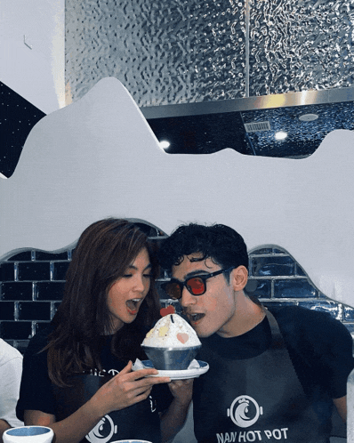 a man and a woman are eating ice cream from a navy hot pot