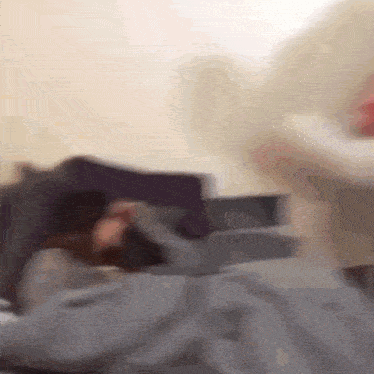 a blurry picture of a person laying on a bed with a purple pillow