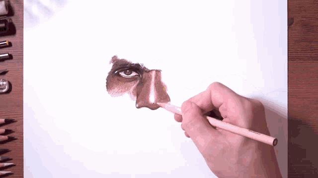 a person is drawing a nose with a pencil on a piece of paper