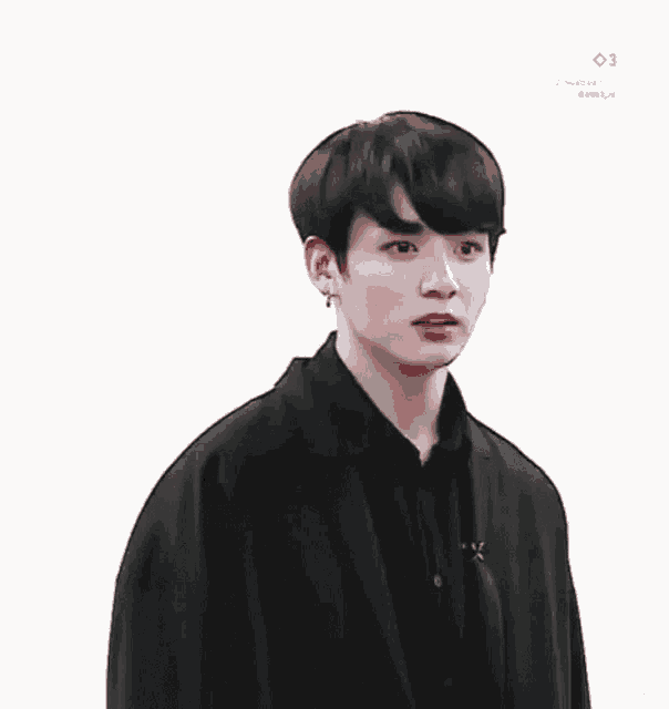a young man is making a funny face while wearing a black jacket and a black shirt .