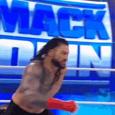 a wrestler in a boxing ring with the word mack down behind him