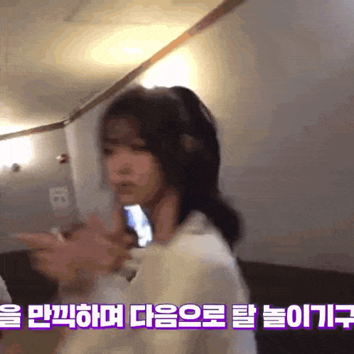 a woman is standing in a room with korean writing on it