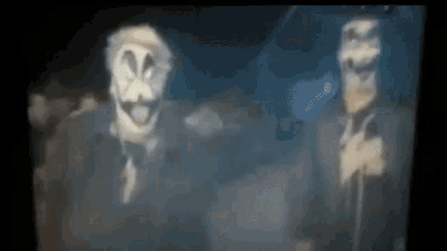 two men in suits and masks are standing next to each other .