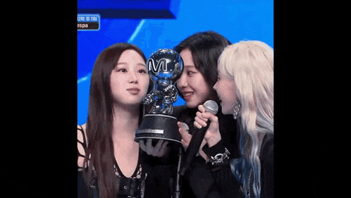 three women holding a trophy that says mv