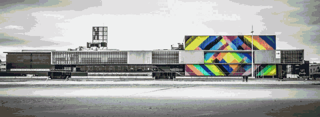a black and white photo of a large building with a colorful geometric pattern on the side