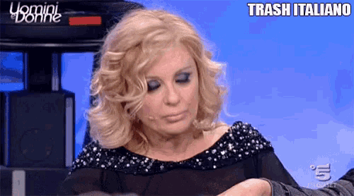 a woman sitting in front of a screen that says trash italiano on it